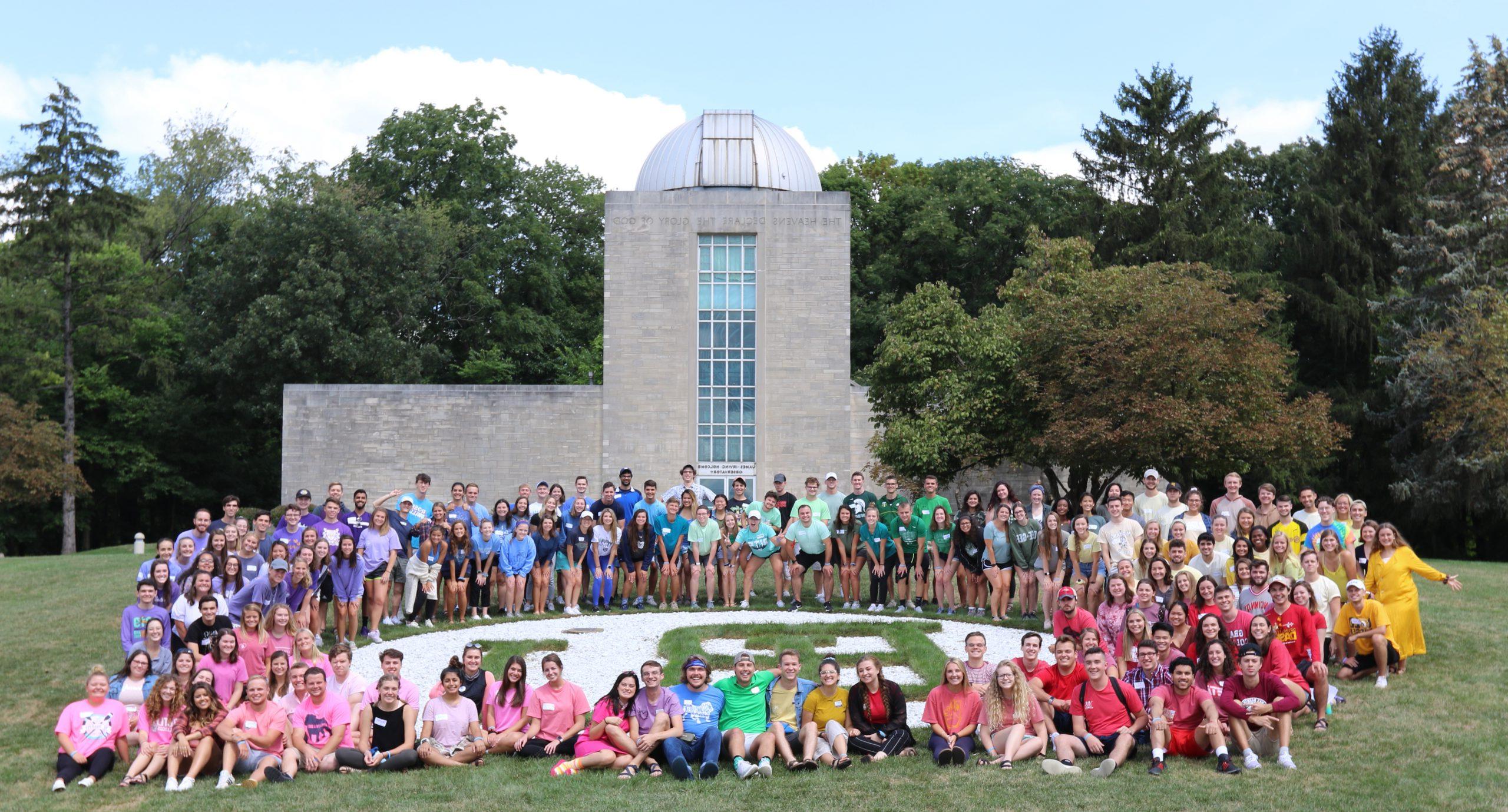 student orientation guides in rainbow shirts in front of holcomb observatory